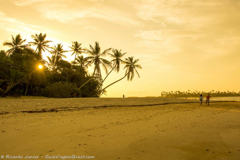 Imagem de casal caminhando no entardecer-Praia da Boca da Barra.